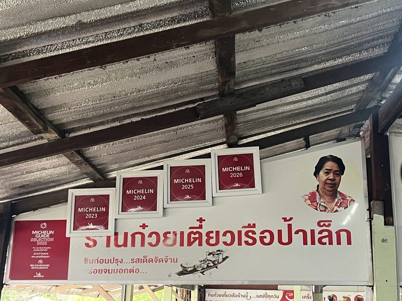 ป้ายชื่อร้านก๋วยเตี๋ยวเรือป้าเล็ก กับป้ายมิชลิน ไกด์ 2022 บิบ กูร์มองด์ และป้ายปี 2023 ถึง 2026